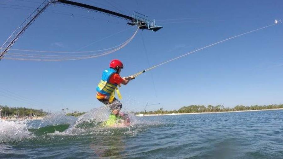 Wasserskifahrer startet an einer Seilbahn über dem Wasser