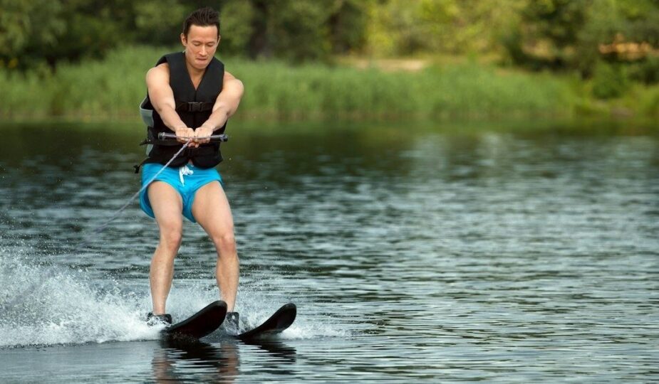 Wasserskifahrer mit zwei Skiern beim Kantenwechsel auf einem See