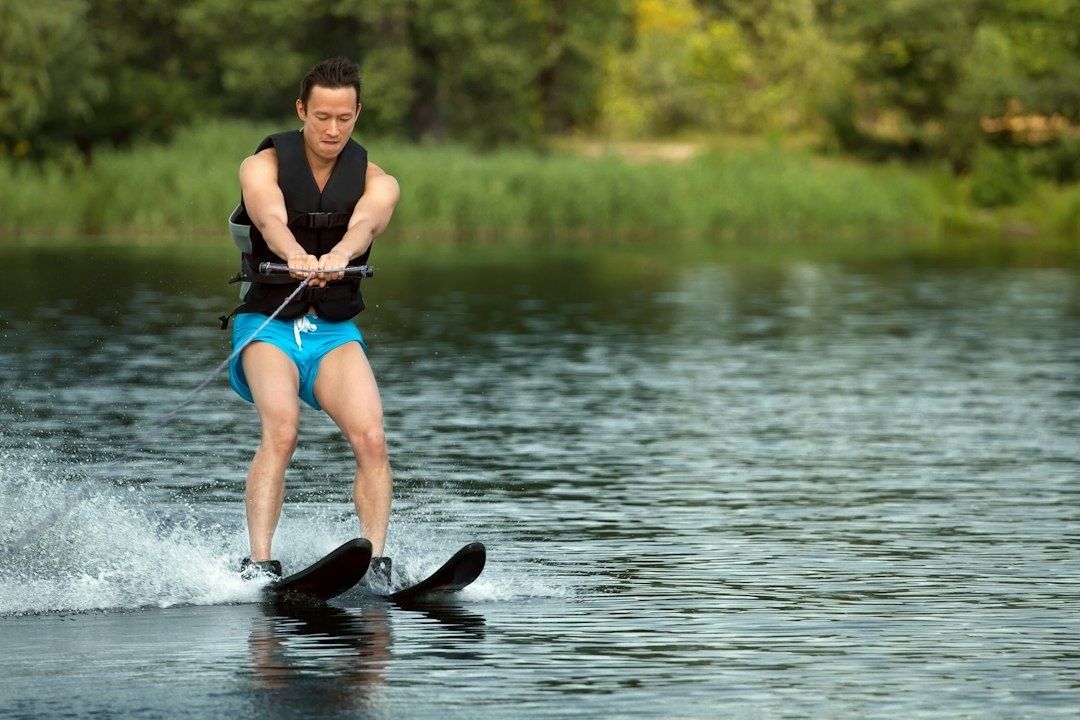 Wasserskifahrer mit zwei Skiern beim Kantenwechsel auf einem See