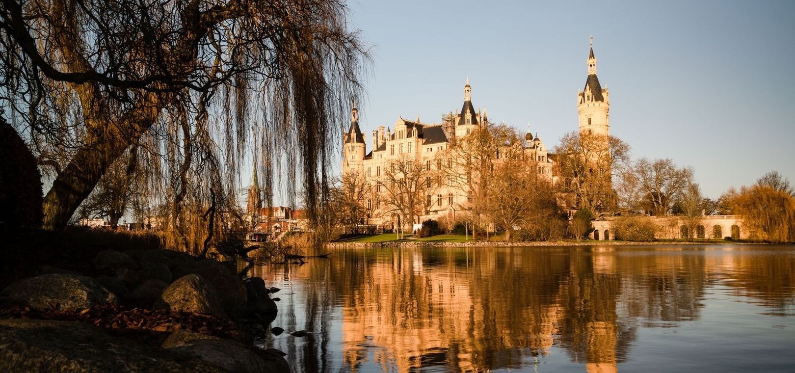 Historisches Schloss am See mit Türmen und Spiegelung im Wasser