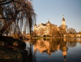 Historisches Schloss am See mit Türmen und Spiegelung im Wasser