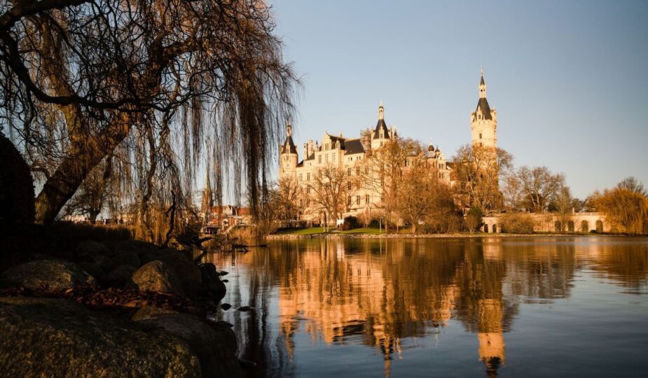 Historisches Schloss am See mit Türmen und Spiegelung im Wasser